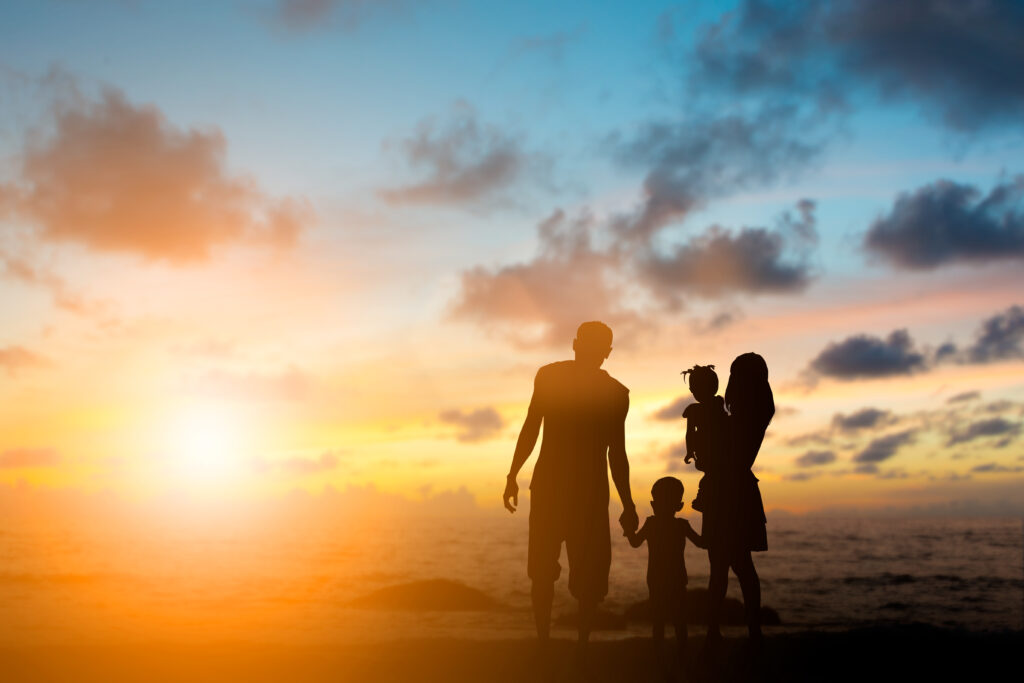silhouette family mother, father and young son holding hands, ta