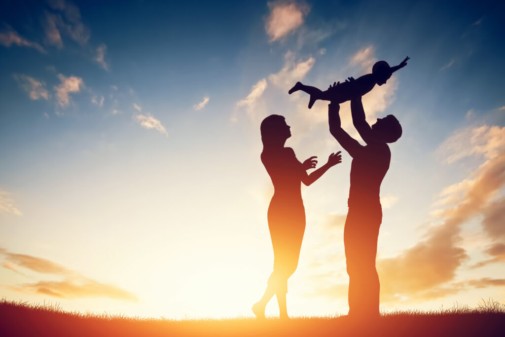 happy family together, parents with their little child at sunset.